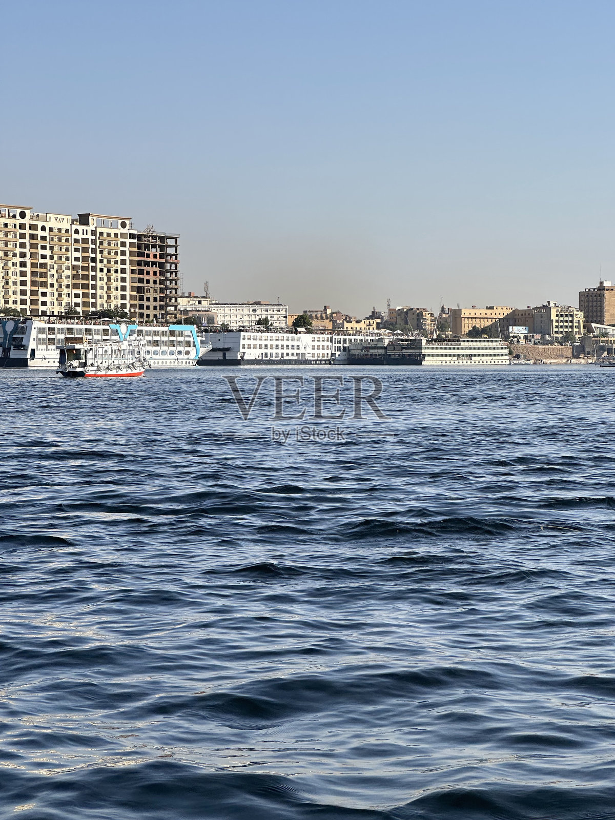 在埃及阿斯旺的阳光明媚的下午,尼罗河上航行的费卢卡帆船照片摄影图片