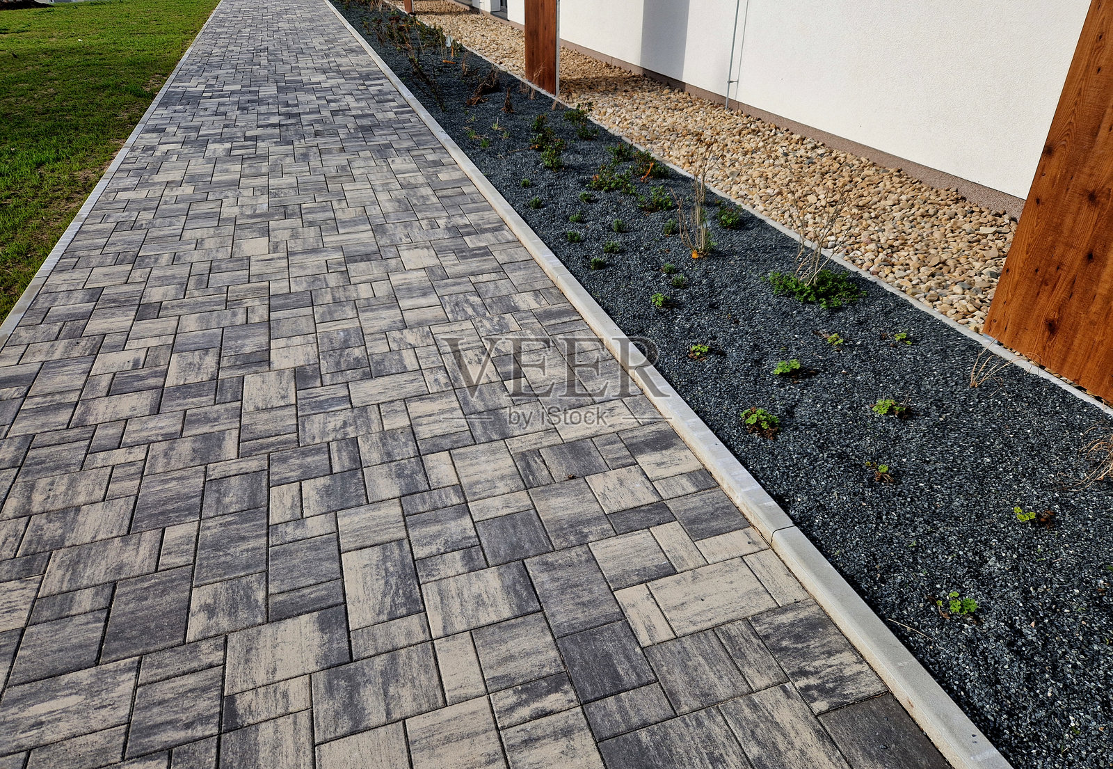 城市环境中五彩斑斓的草原花卉床吸引昆虫和蝴蝶,铺有碎石。精油的角落有大石块,交错在边缘。照片摄影图片