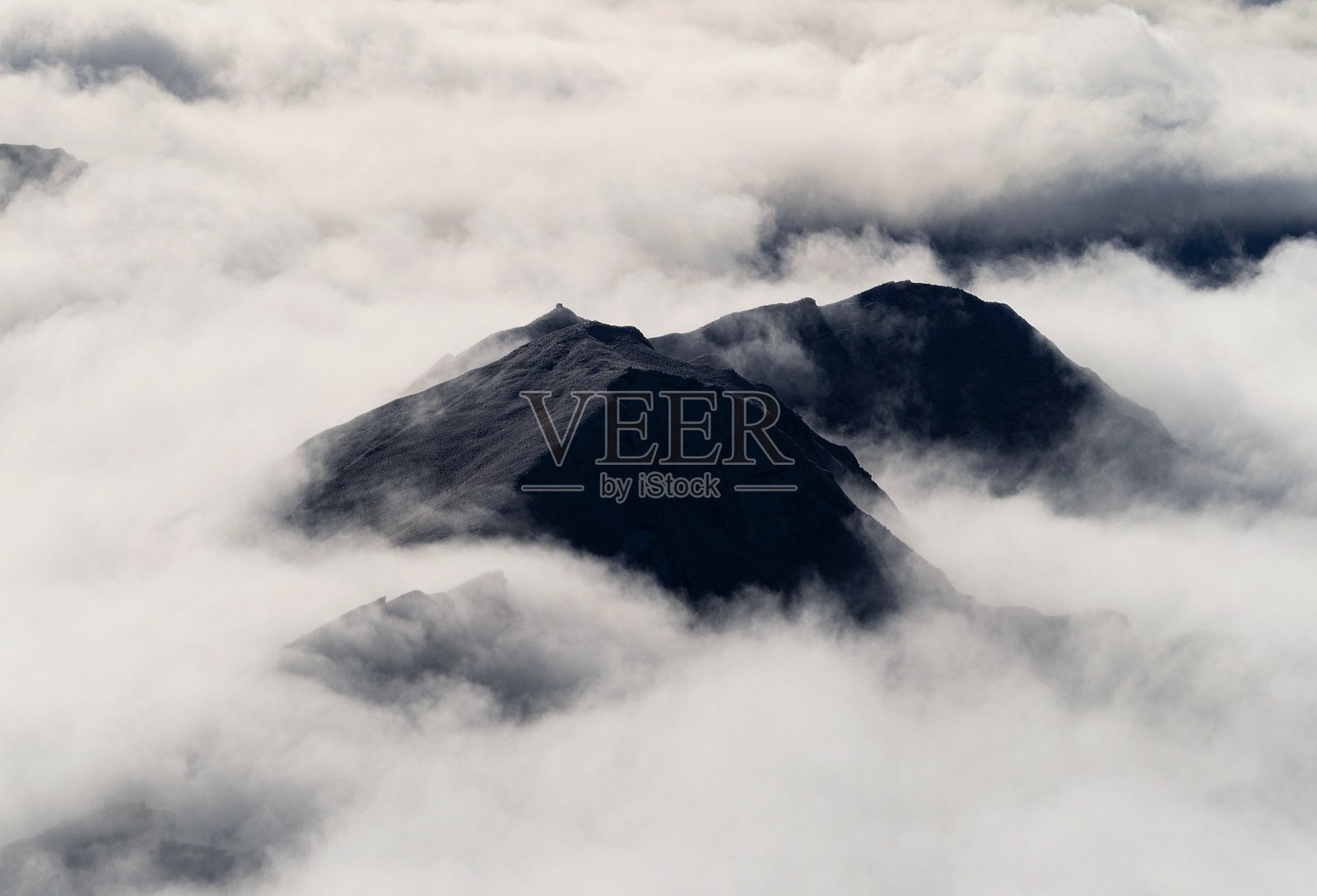 南阿尔卑斯山的空中全景,雪山巅峰高于云层,位于新西兰南岛的奥塔哥南部。照片摄影图片