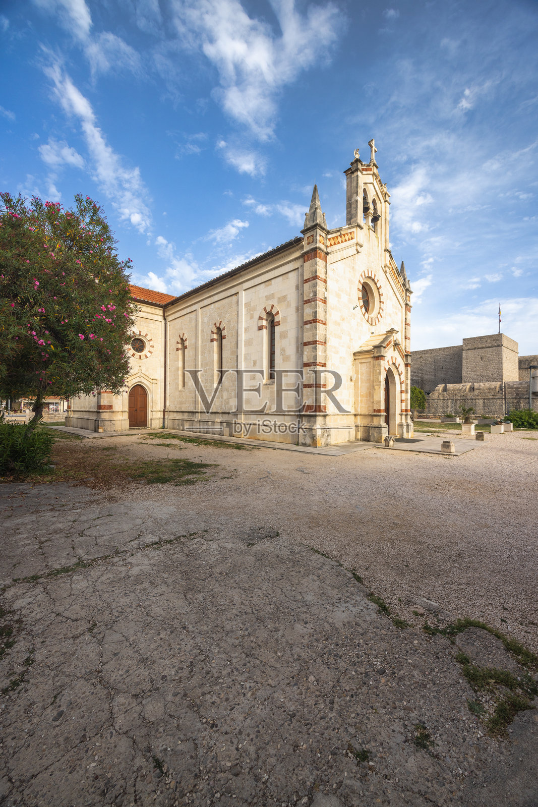 克罗地亚佩尔耶萨茨半岛的历史名镇斯通。风景如画的小教堂,石质外立面和钟楼在蓝天和柔和云朵的衬托下显得宁静。照片摄影图片