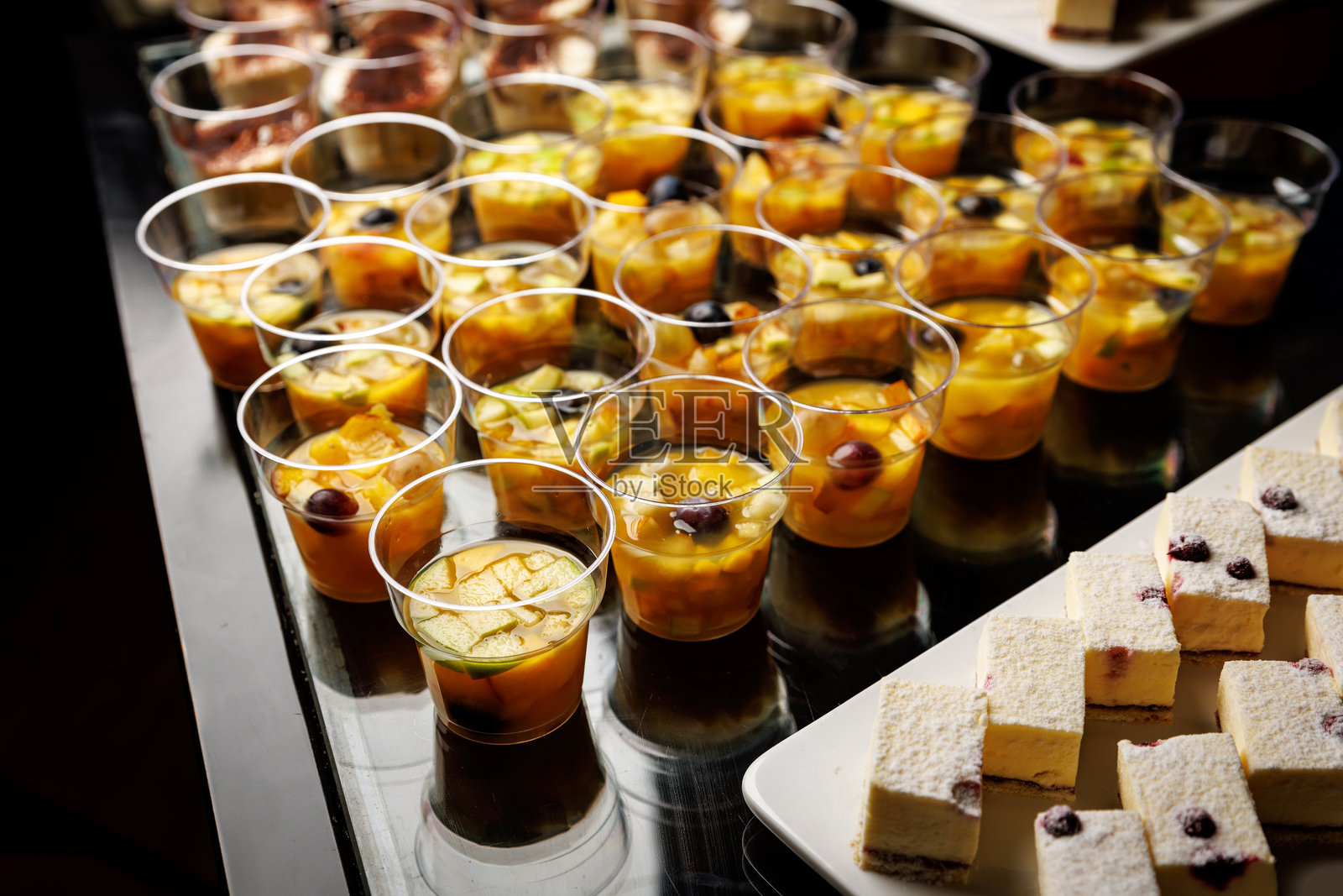 黑色表面上的水果沙拉杯照片摄影图片