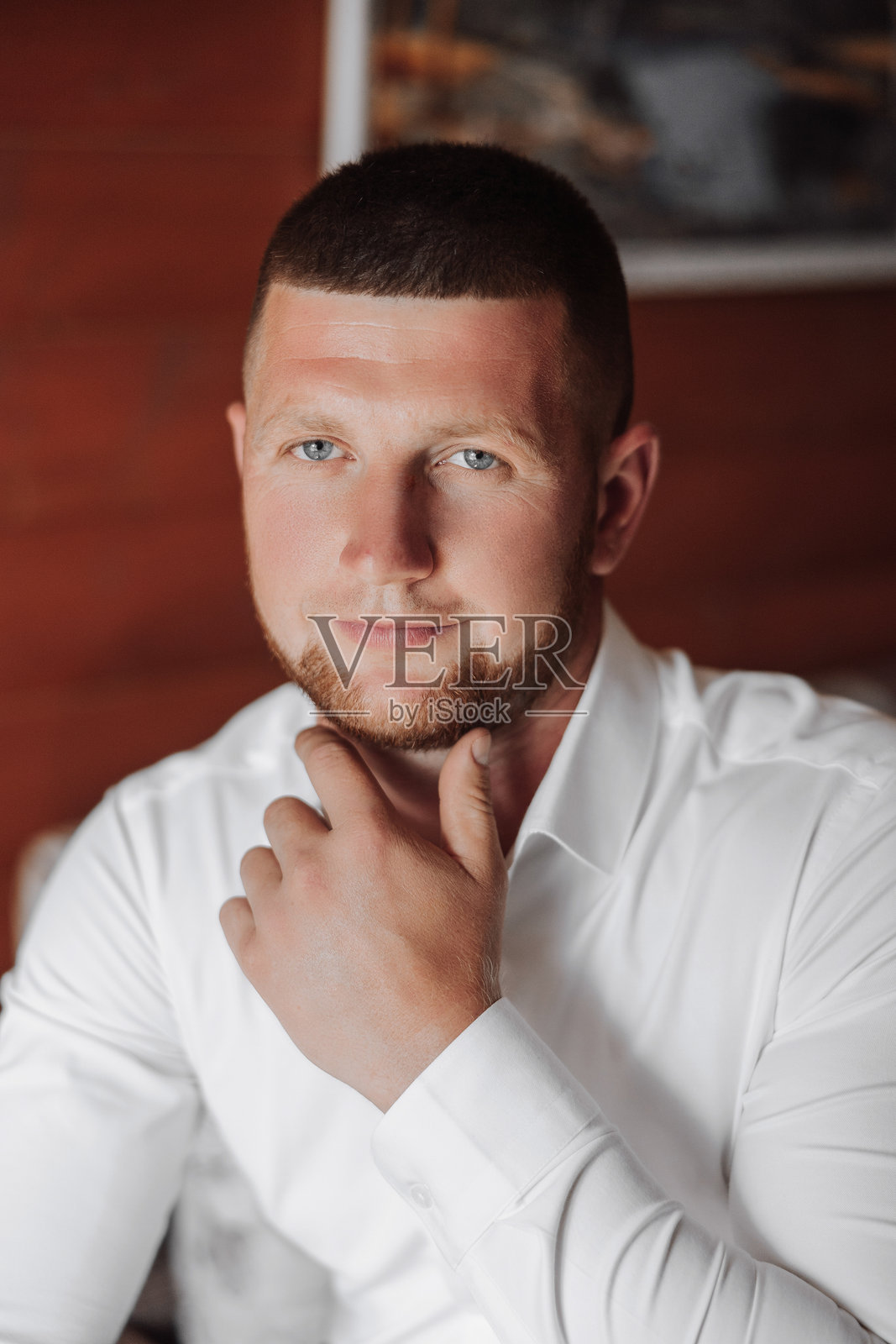 一个留着胡子的男人穿着白衬衫坐在沙发上照片摄影图片