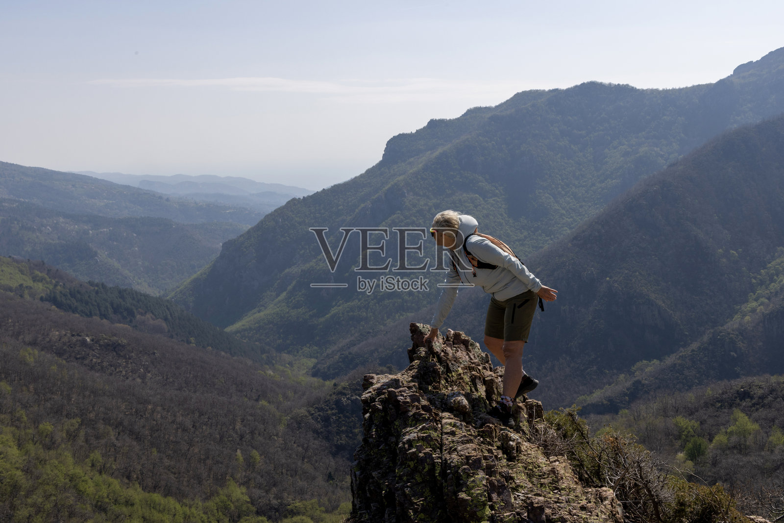 成熟的女性在山顶攀爬照片摄影图片