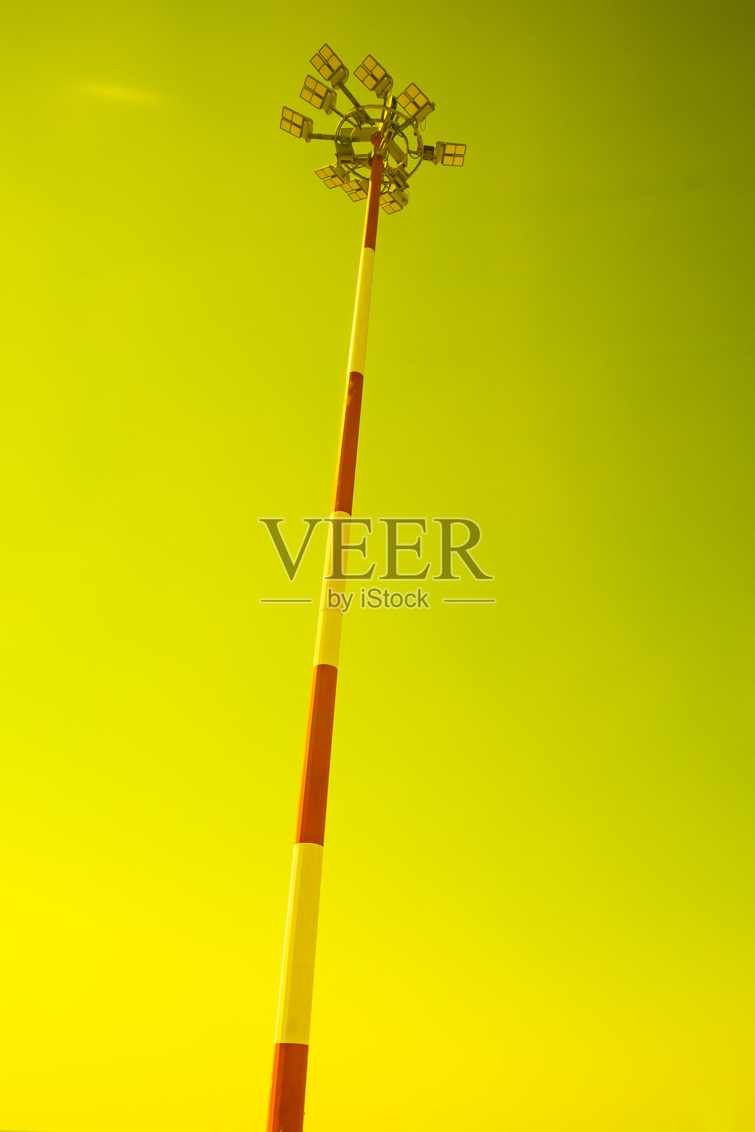 机场泛光灯塔在晴朗的天空下,黄色滤镜照片摄影图片