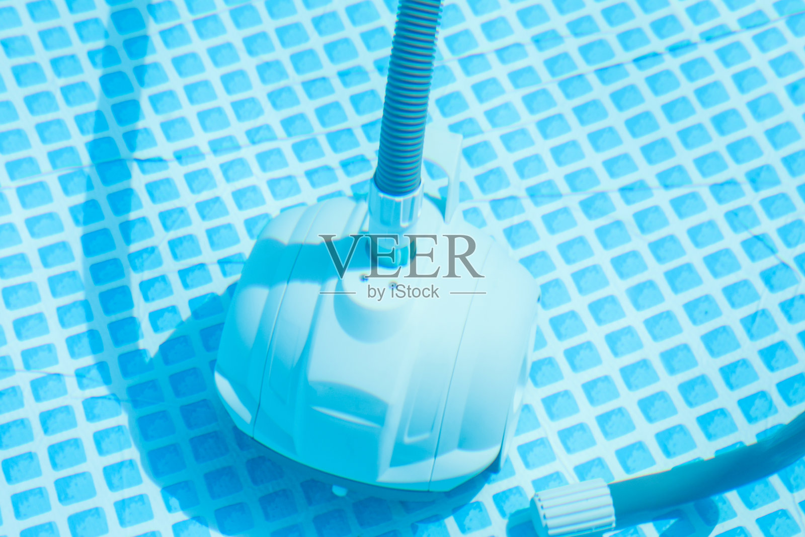 一个在户外游泳池中的机器人清洁器照片摄影图片