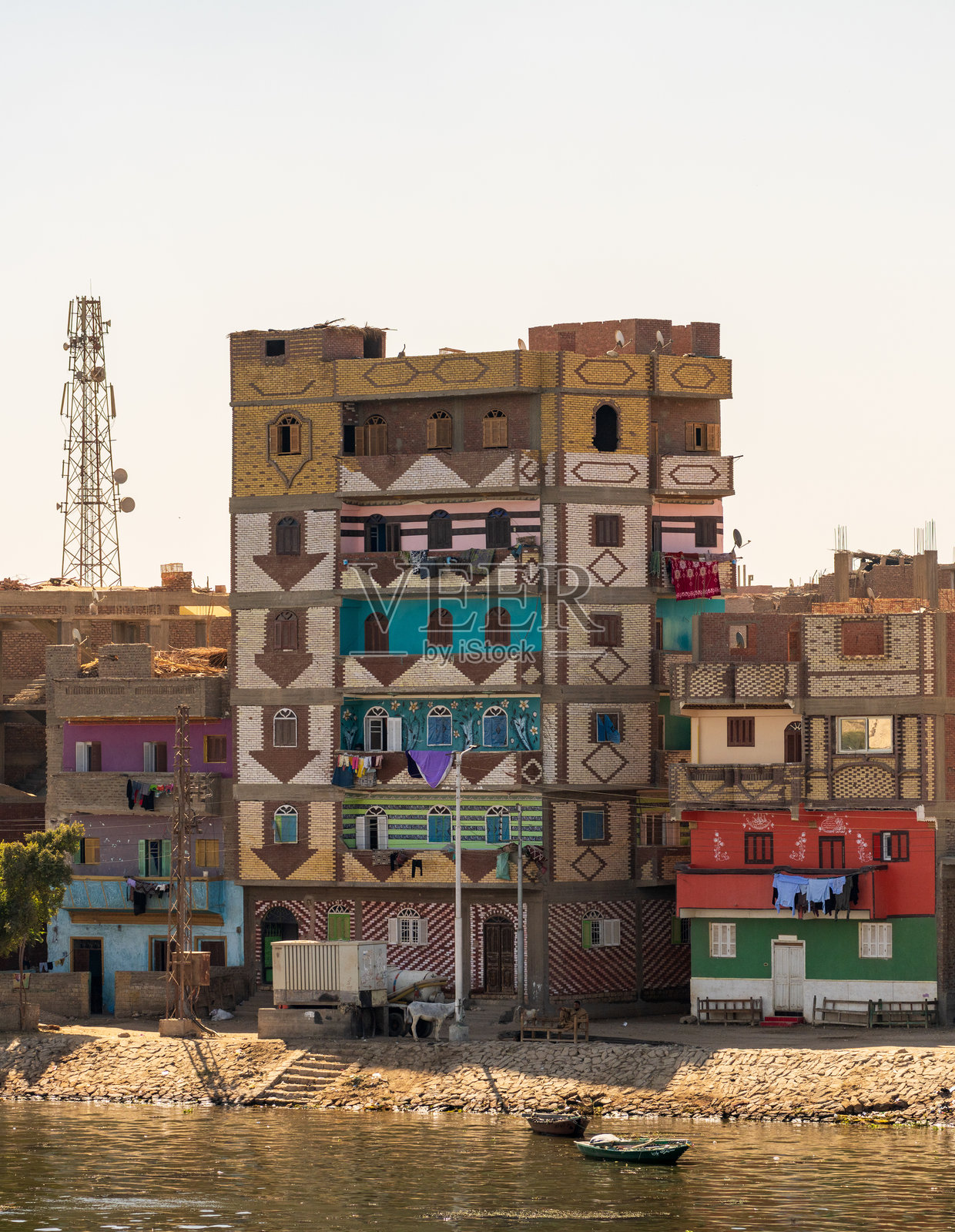 尼罗河沿岸的埃斯纳生机勃勃的景色,色彩斑斓的建筑和宁静的水边。照片摄影图片