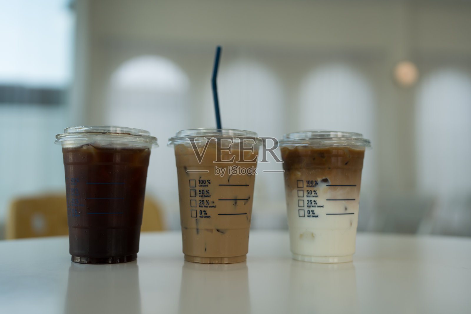 三杯外带冰咖啡放在咖啡馆的桌子上。照片摄影图片