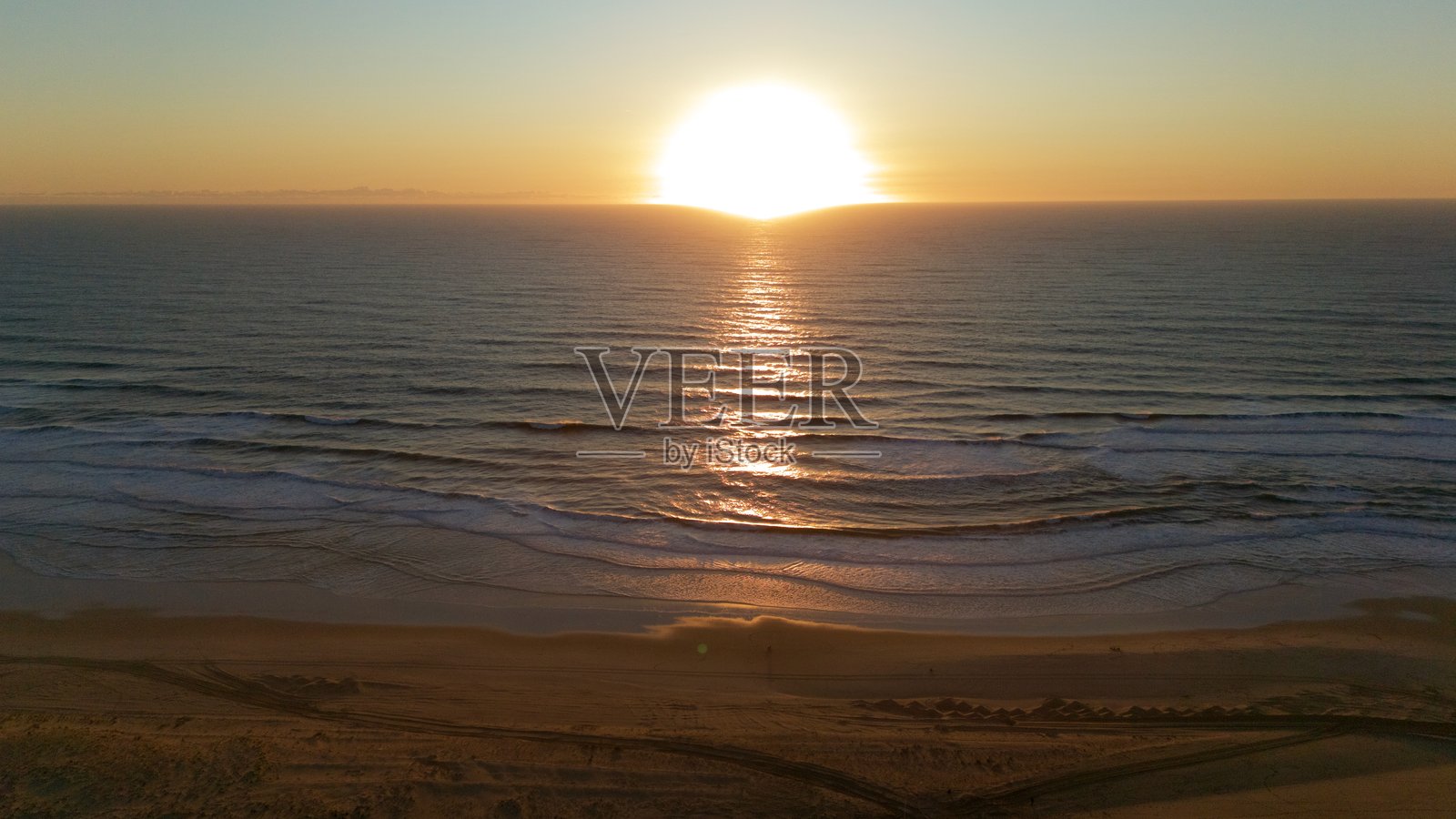 海浪和沙滩上空的日落无人机视角照片摄影图片