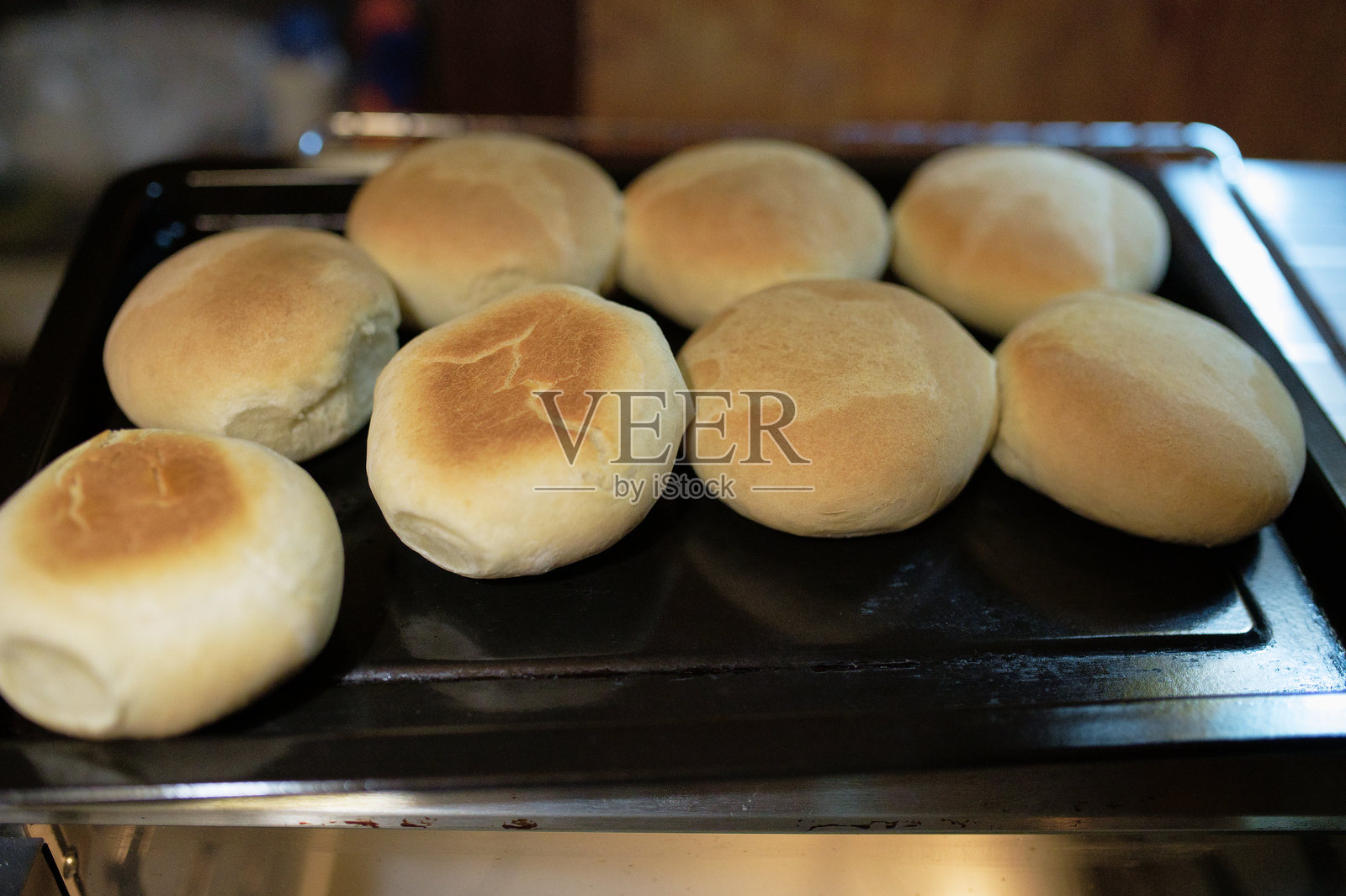 一位女性在揉面团以制作揉面包,然后将其放入电烤箱中烘烤的照片照片摄影图片