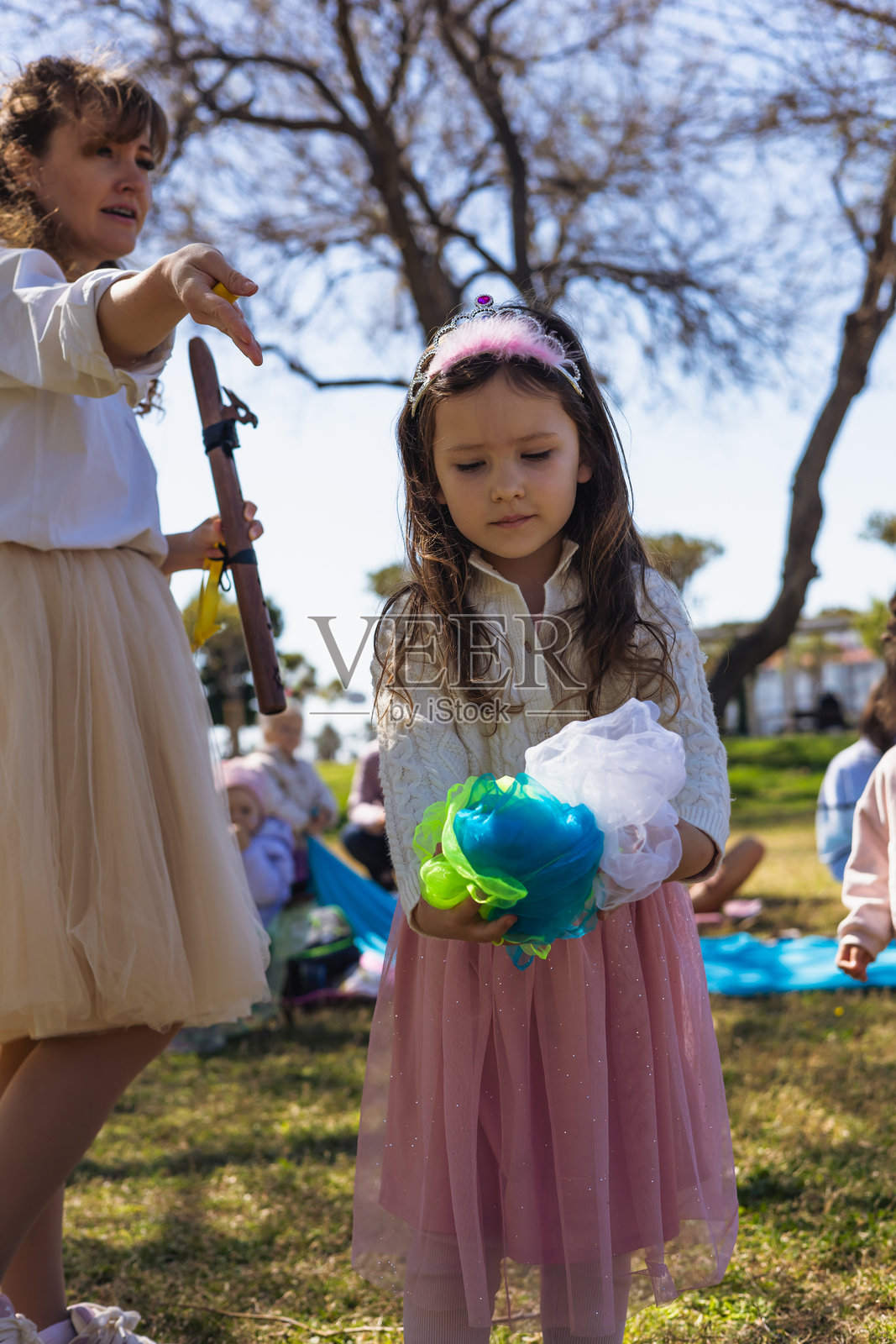 孩子在公园里享受户外活动,手里拿着一个五彩缤纷的手工艺品照片摄影图片