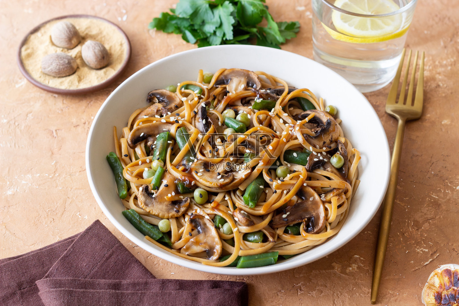 照烧酱乌冬面配蘑菇、豆类和豌豆。亚洲美食。素食。照片摄影图片