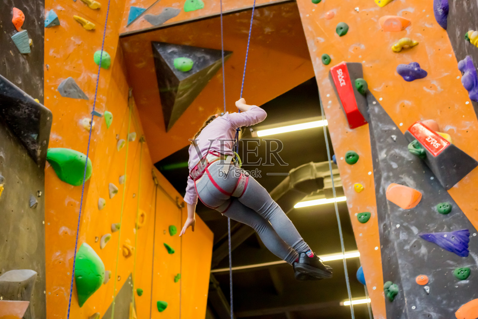 年轻女孩在室内攀岩馆锻炼照片摄影图片