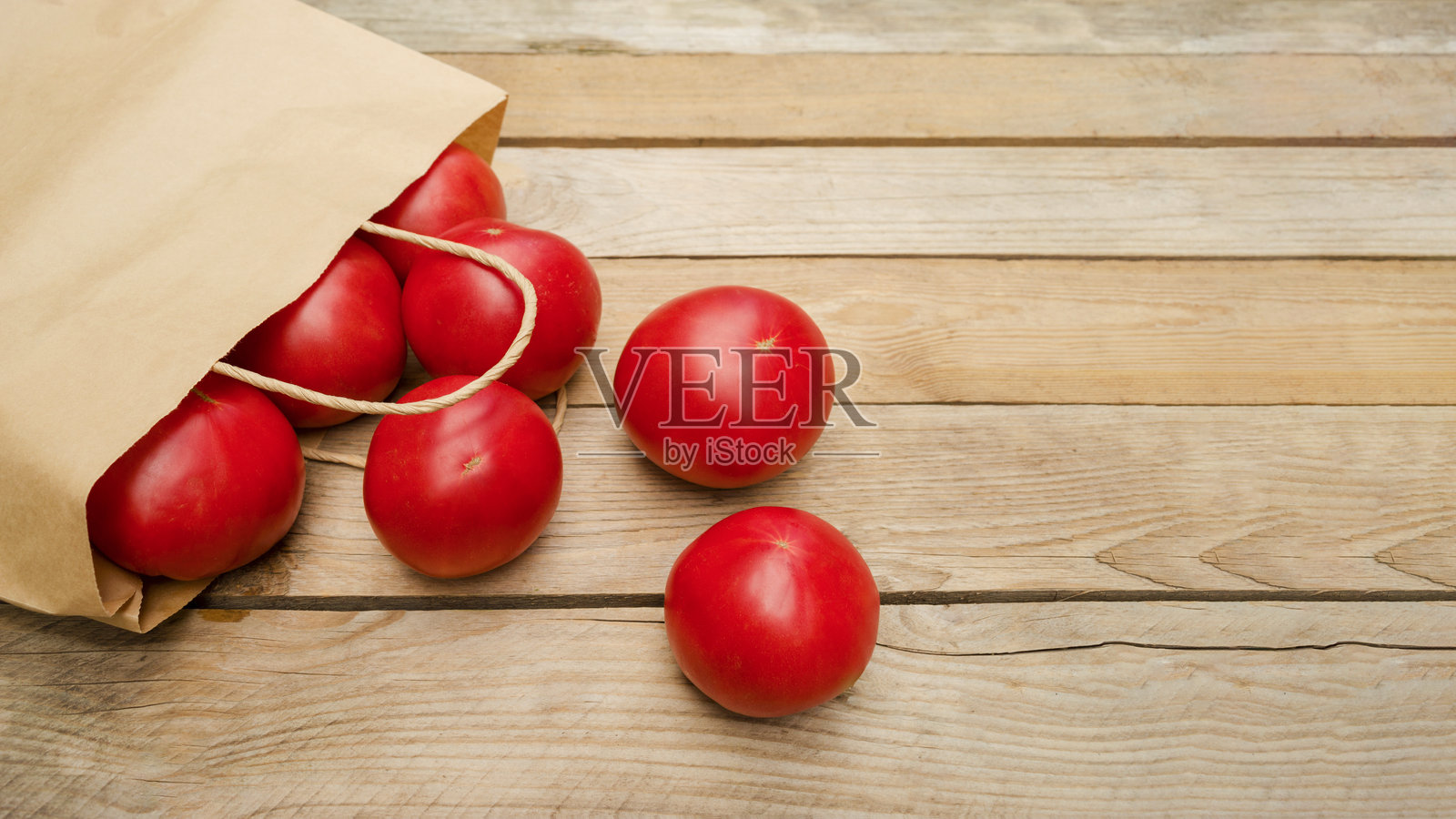 新鲜的番茄从环保纸袋中滚落出来照片摄影图片