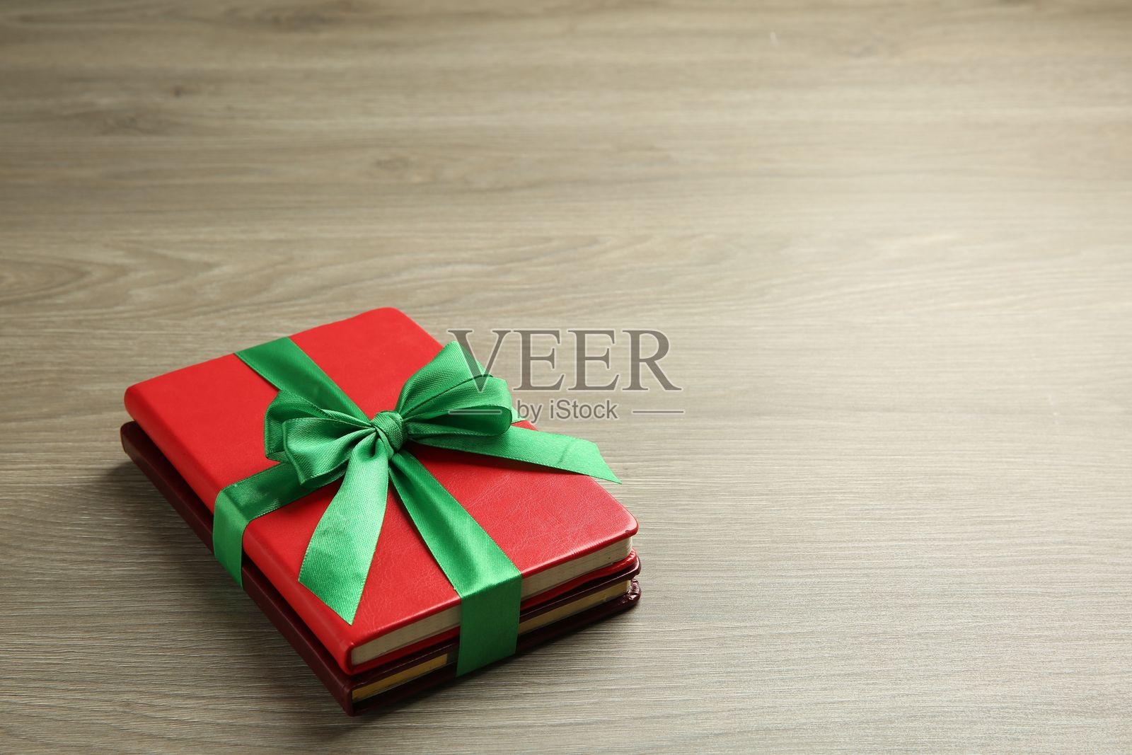 木桌上的带丝带的书籍作为礼物,留有文字空间照片摄影图片