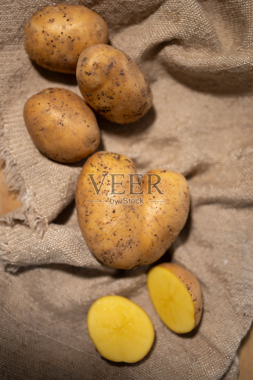 新鲜采摘的土豆优雅地摆放在美丽的乡村布背景上照片摄影图片