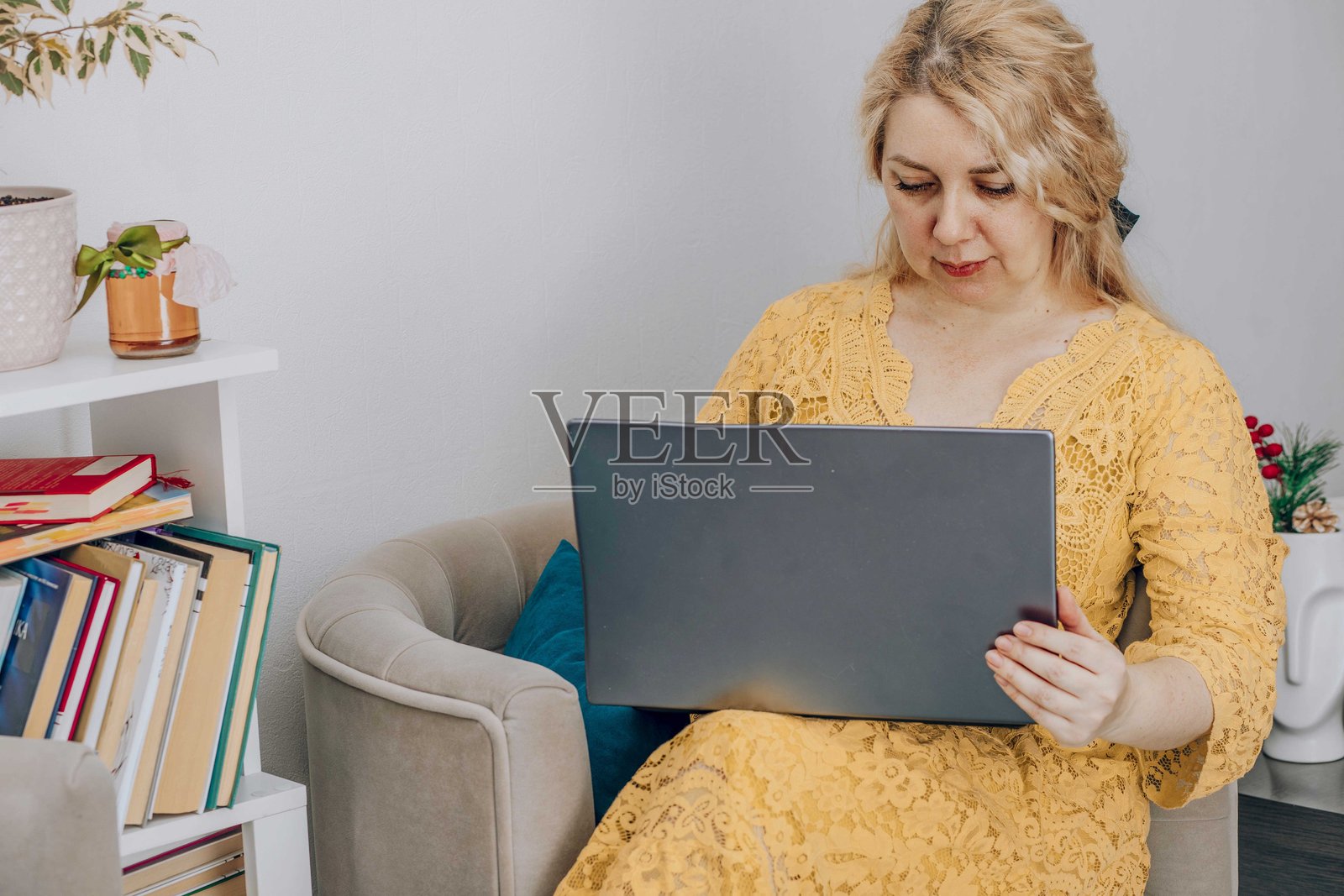 在家办公室中工作的女商人,放松的环境中有植物和装饰,体现工作与生活的平衡、远程工作和自雇的概念。照片摄影图片