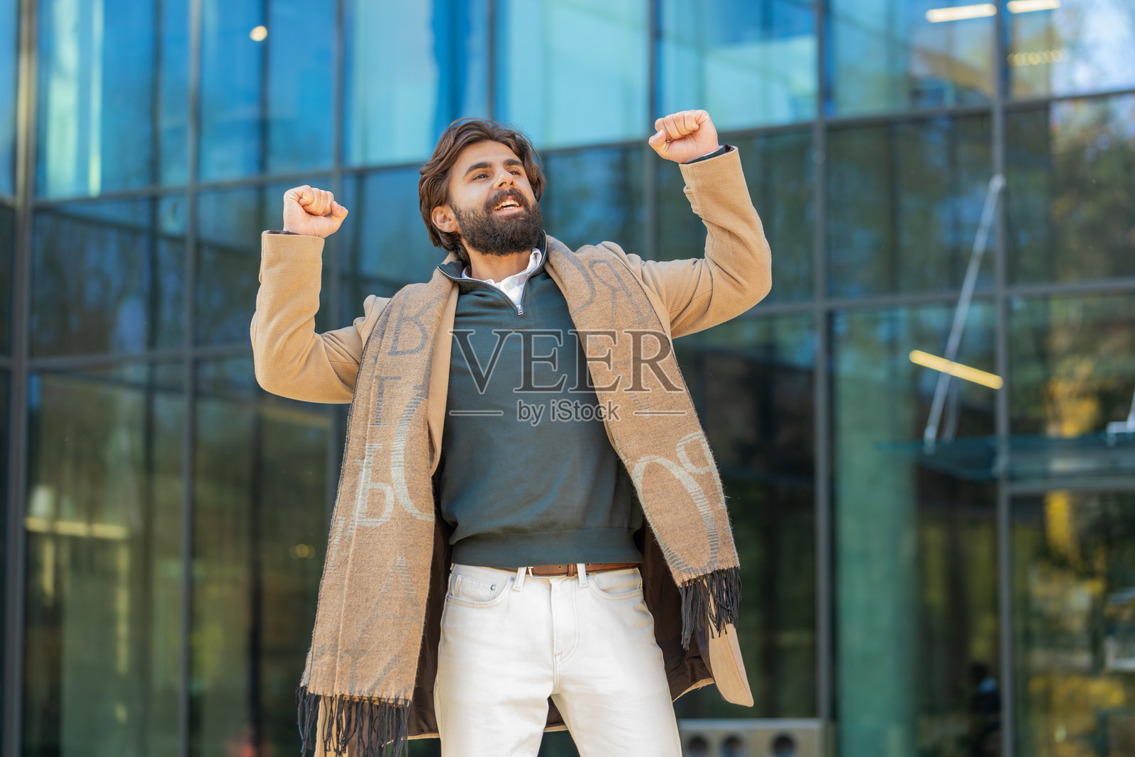 兴奋的男人惊讶地握紧拳头,因突如其来的胜利而震惊,站在城市街道上照片摄影图片