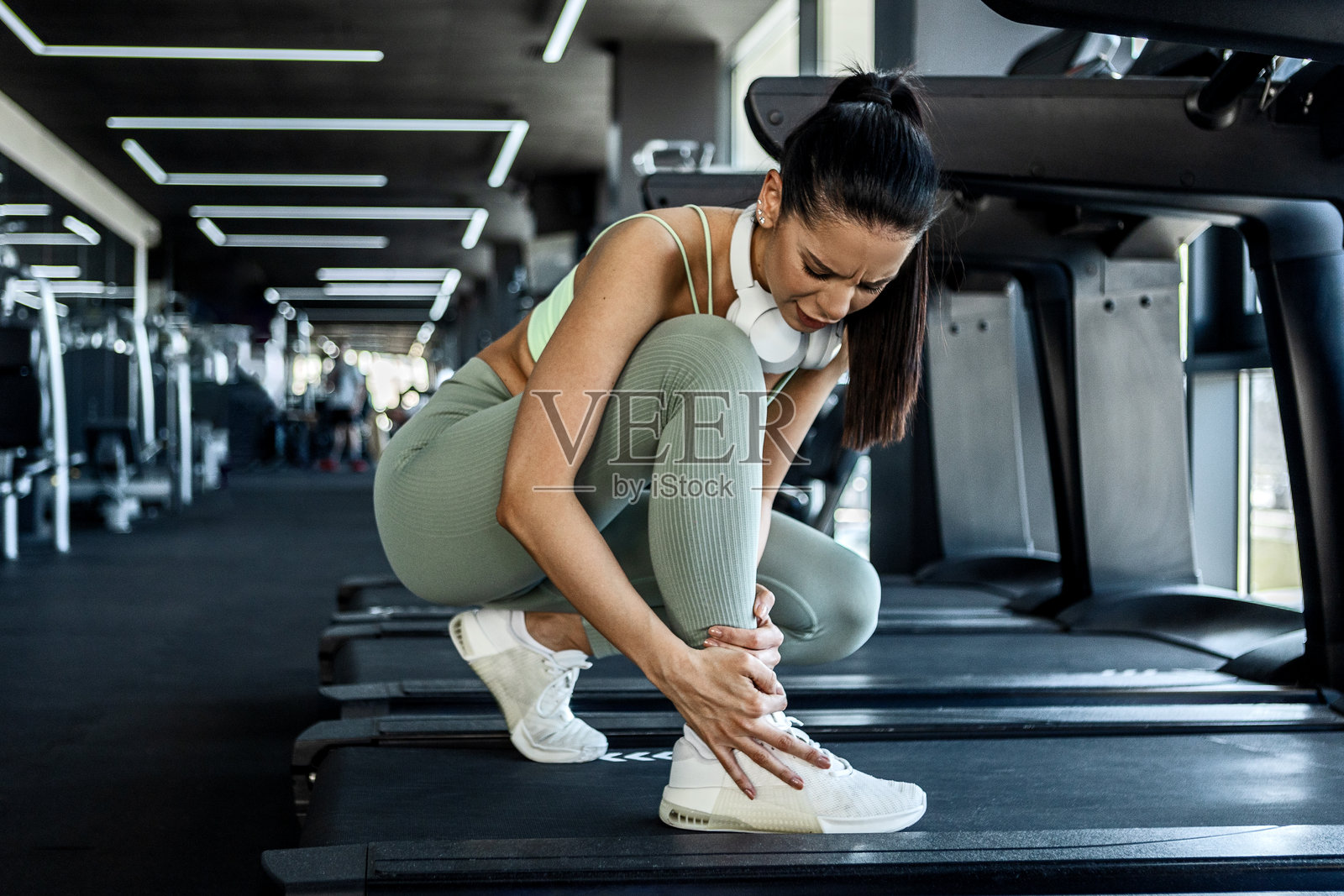 运动女性在锻炼时扭伤脚踝照片摄影图片