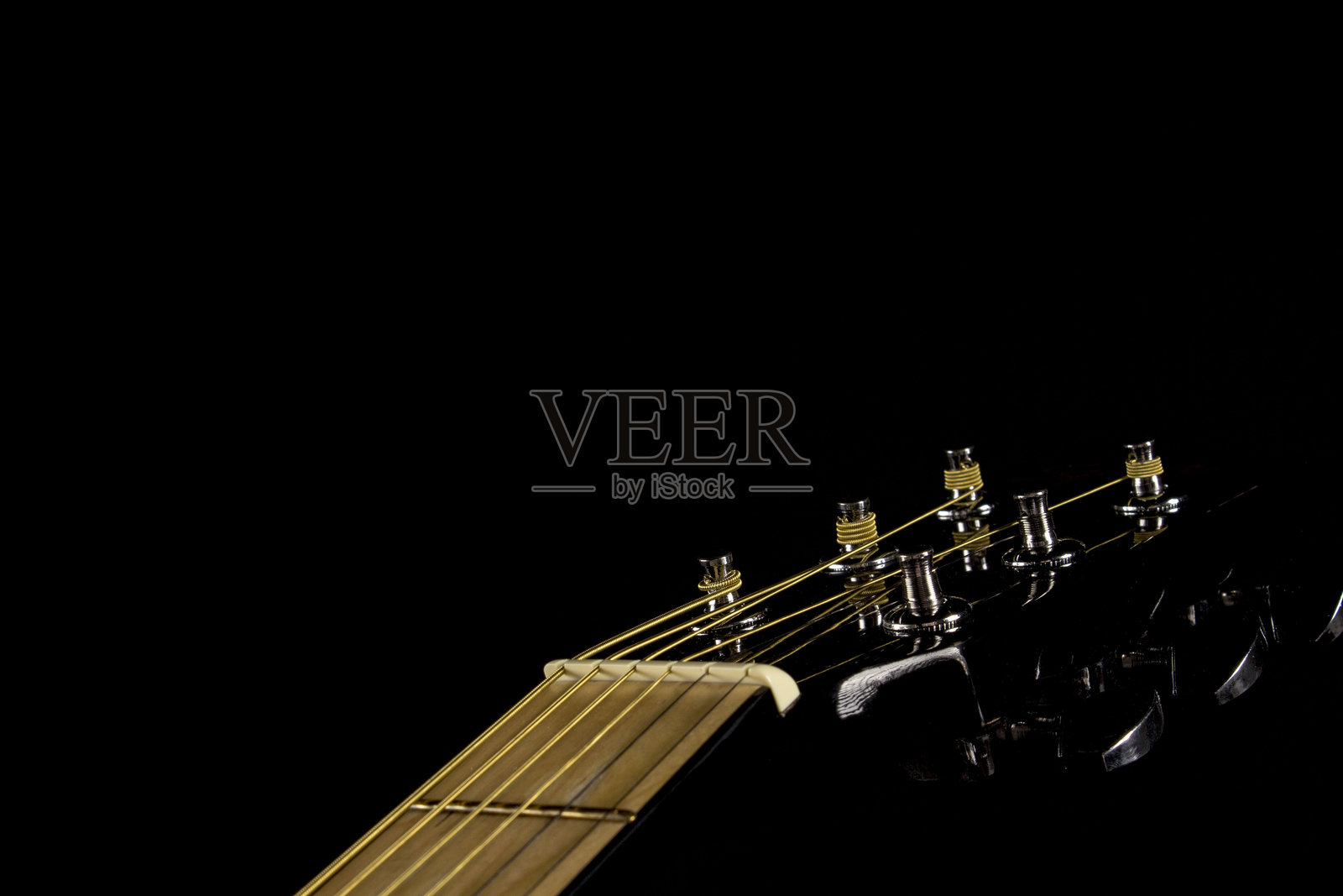 黑色背景上的吉他颈部头部特写。吉他的轮廓。从上方视角。照片摄影图片