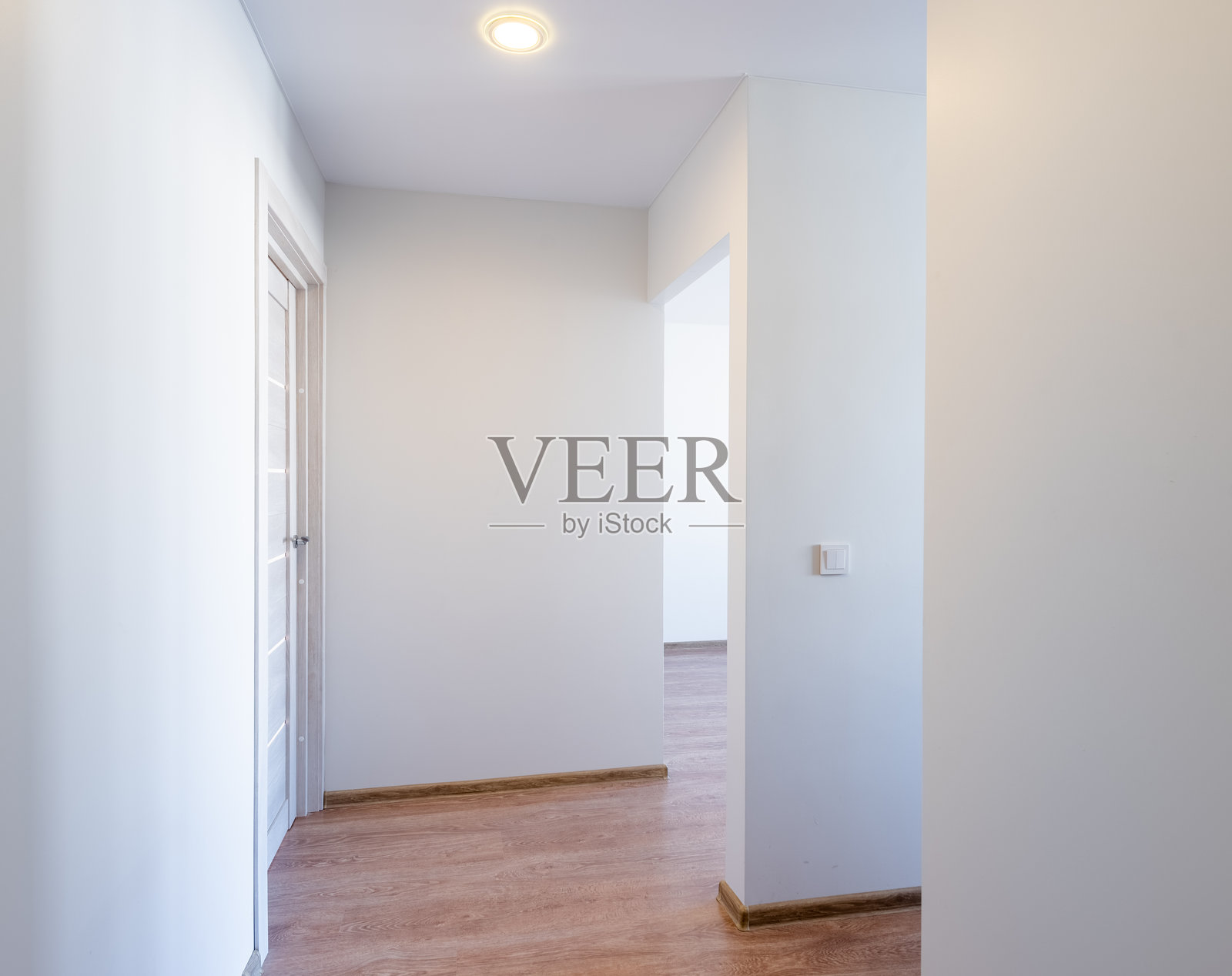 明亮的空房间,木地板和门。白色墙壁的房间角落。门。照片摄影图片