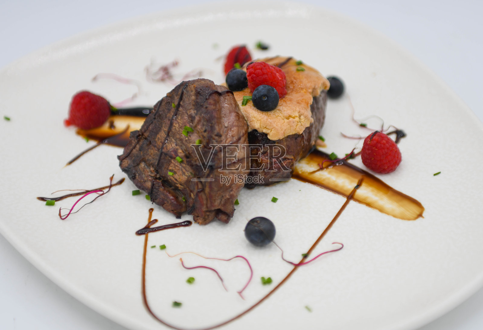 白色背景上的奶油、浆果和巧克力酱甜点照片摄影图片