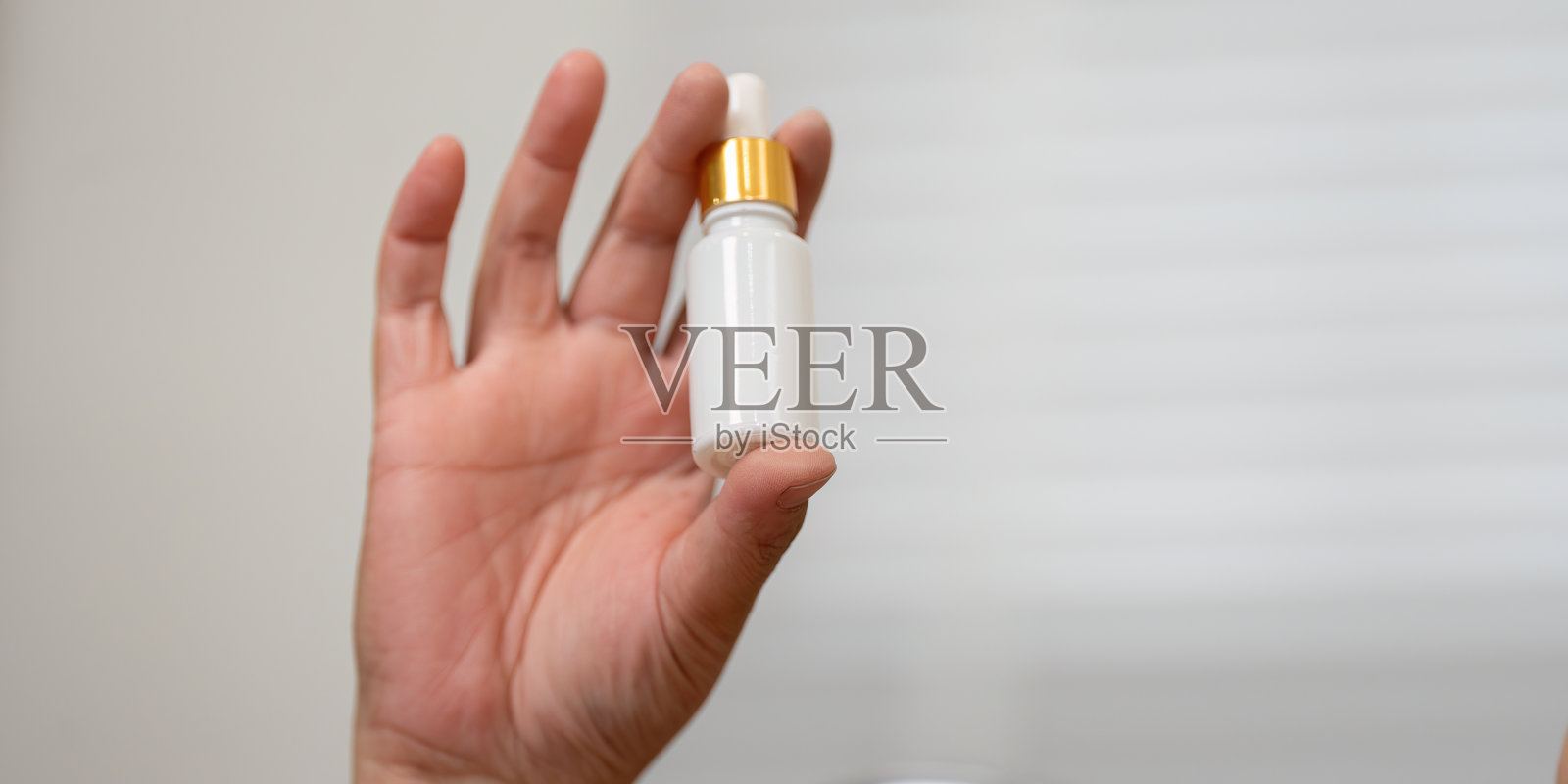 美容精华液和护肤及个人护理。手握美容精华滴管,突显护肤程序中的基本要素。照片摄影图片