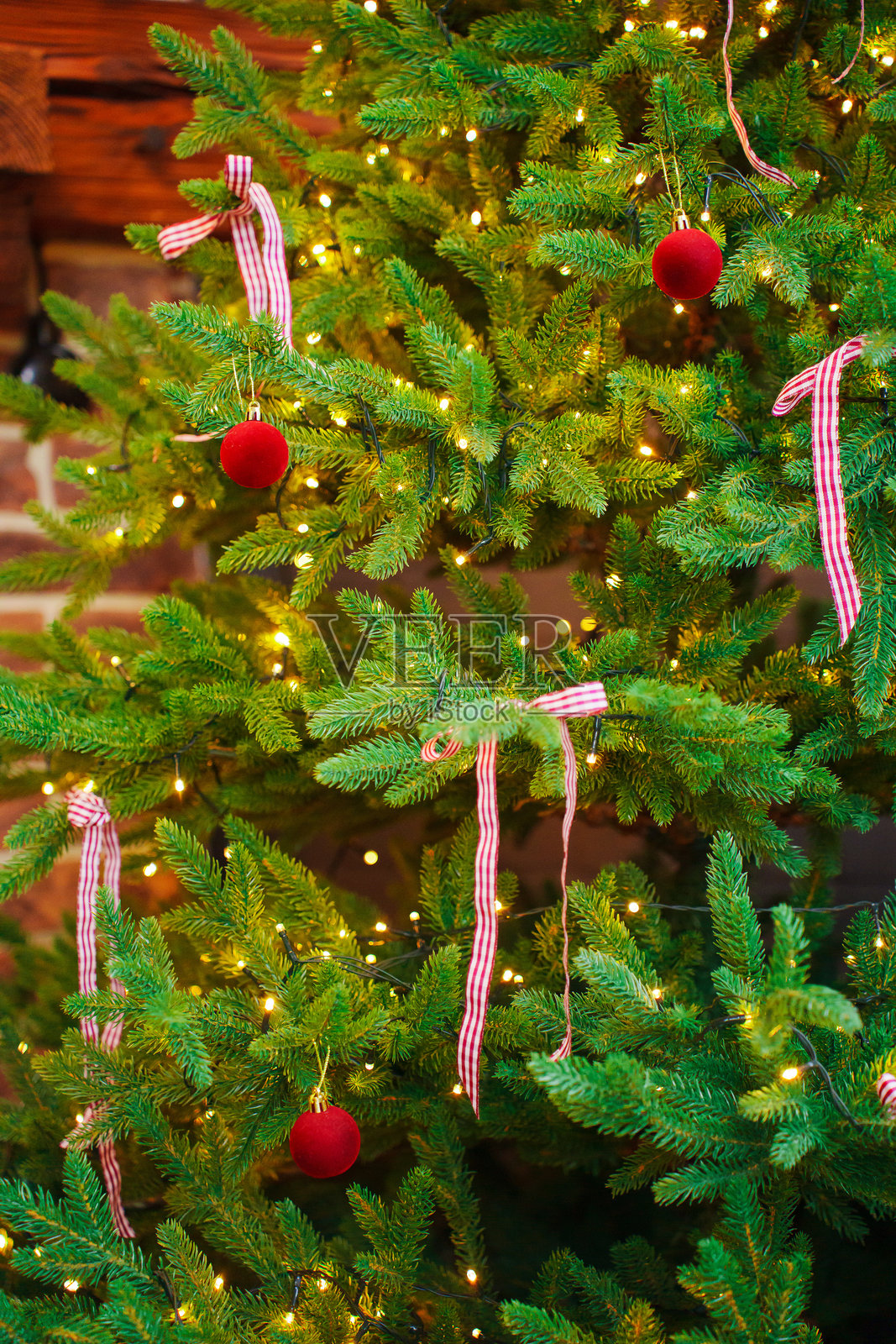 装饰着红色球和蝴蝶结的圣诞树。照片摄影图片