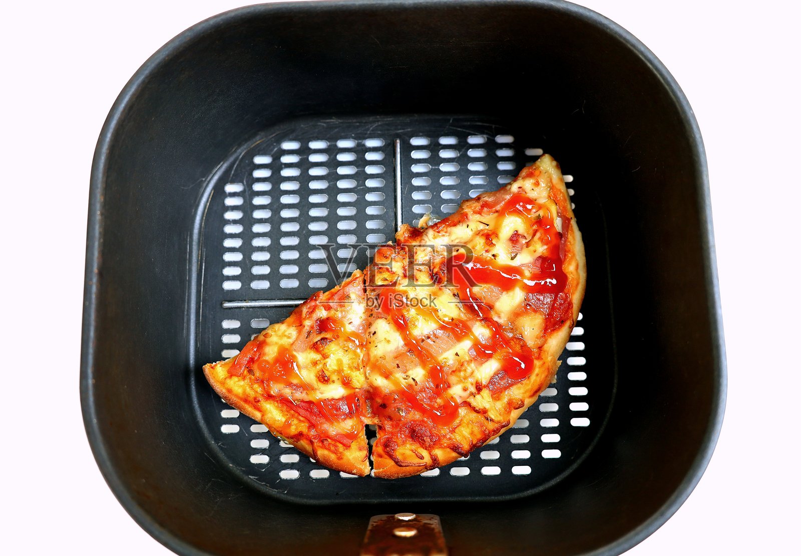 用空气炸锅加热剩余的比萨饼。照片摄影图片