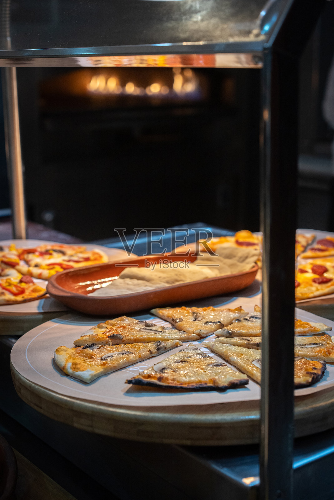 美味的披萨在自助餐的传统烤箱中烘烤。照片摄影图片
