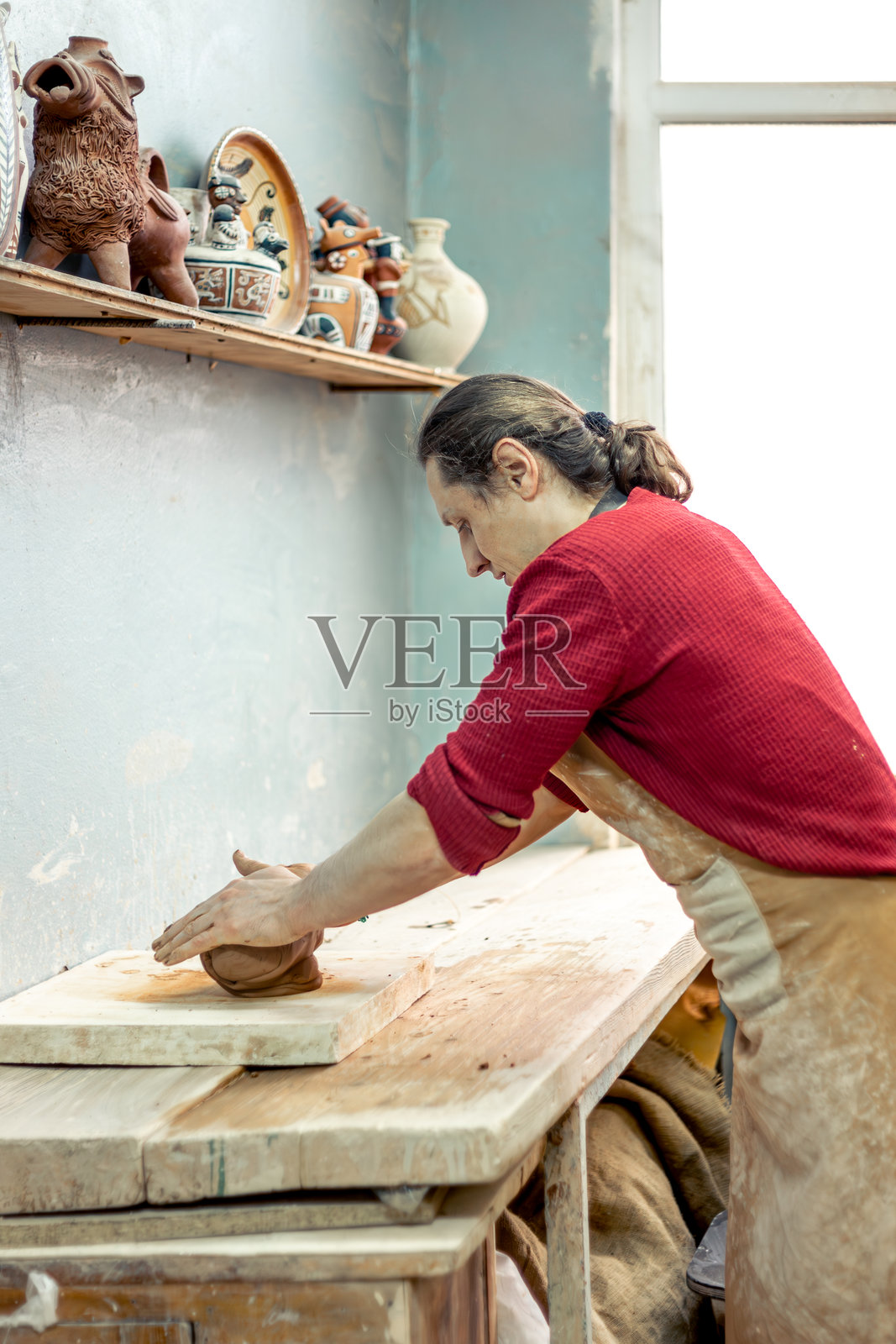 陶艺师在工作。用粘土造型。为陶器制作做准备。照片摄影图片