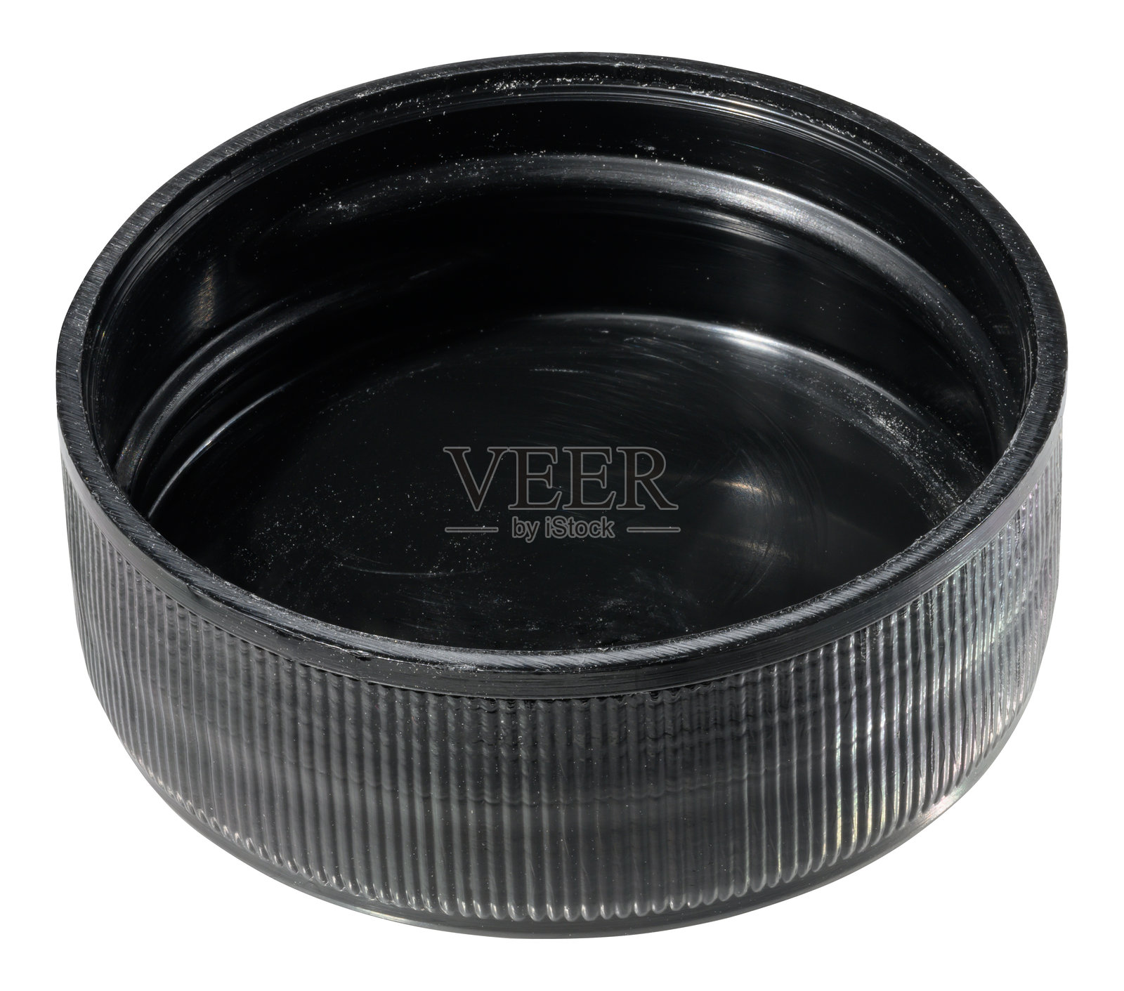 一个圆形的黑色塑料瓶盖,外部有凹槽,内部光滑,背景为单色。照片摄影图片