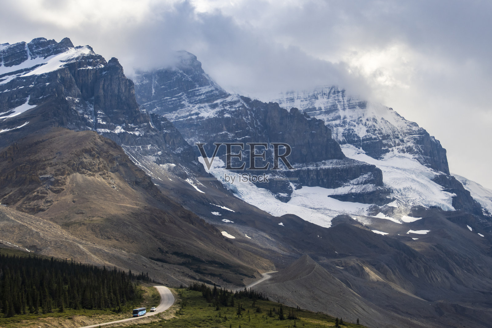 壮丽的山脉在清晨的光线下耸立于加拿大贾斯珀国家公园附近的蜿蜒道路上。照片摄影图片
