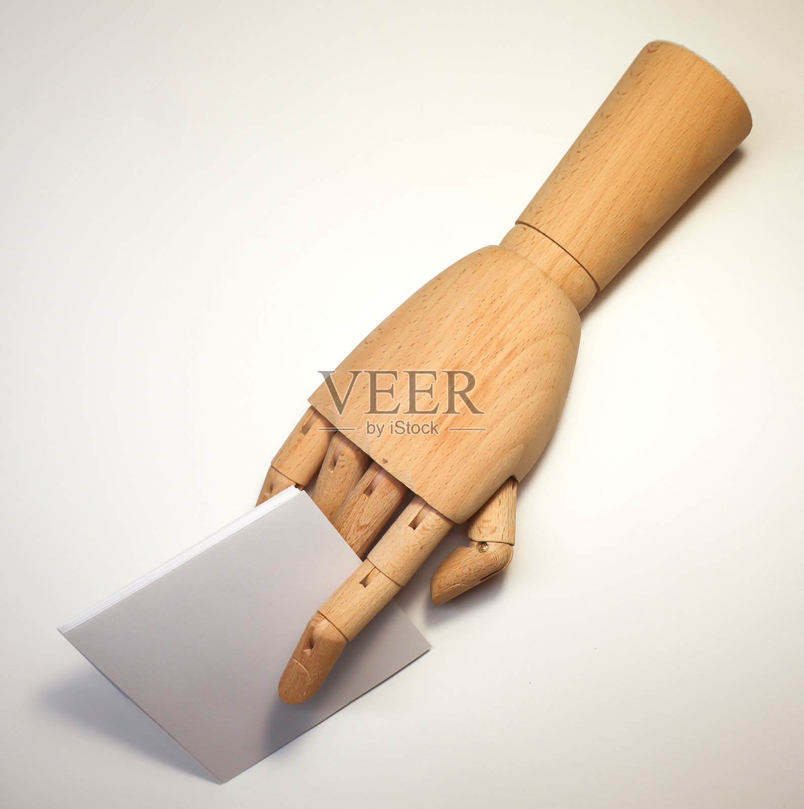 木制人体模型手握着一张空白的白卡片照片摄影图片