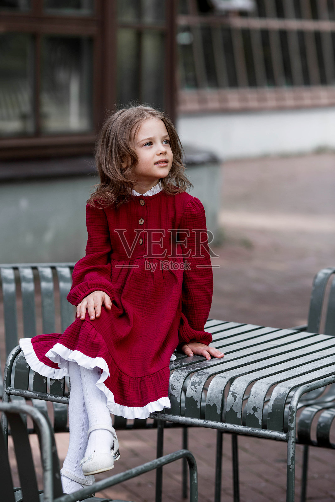 公园里穿着红色裙子的美丽5岁女孩的肖像。童年。照片摄影图片