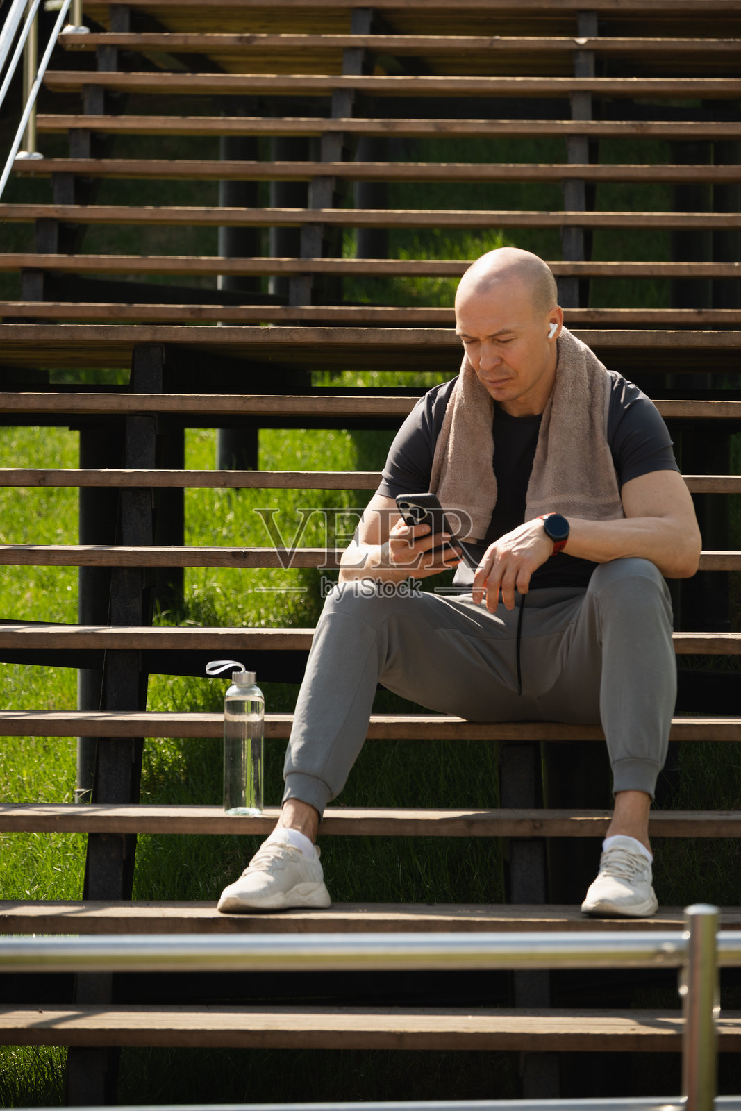 运动男士在训练后使用智能手机发短信和社交媒体。特写。照片摄影图片