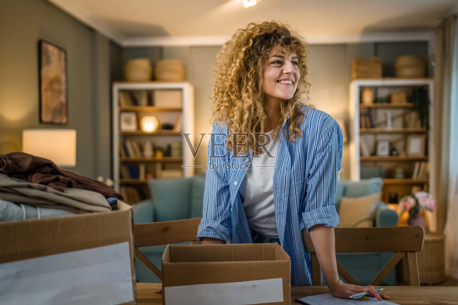 一位年轻女性正在准备衣物以捐赠给慈善机构照片摄影图片