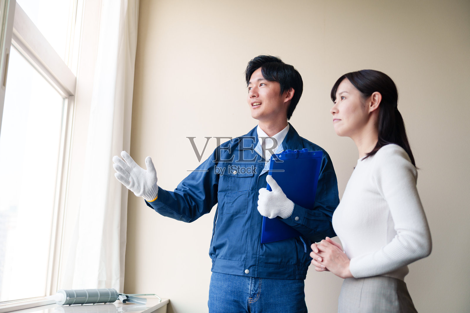 女人请修理工修理她的房子。照片摄影图片