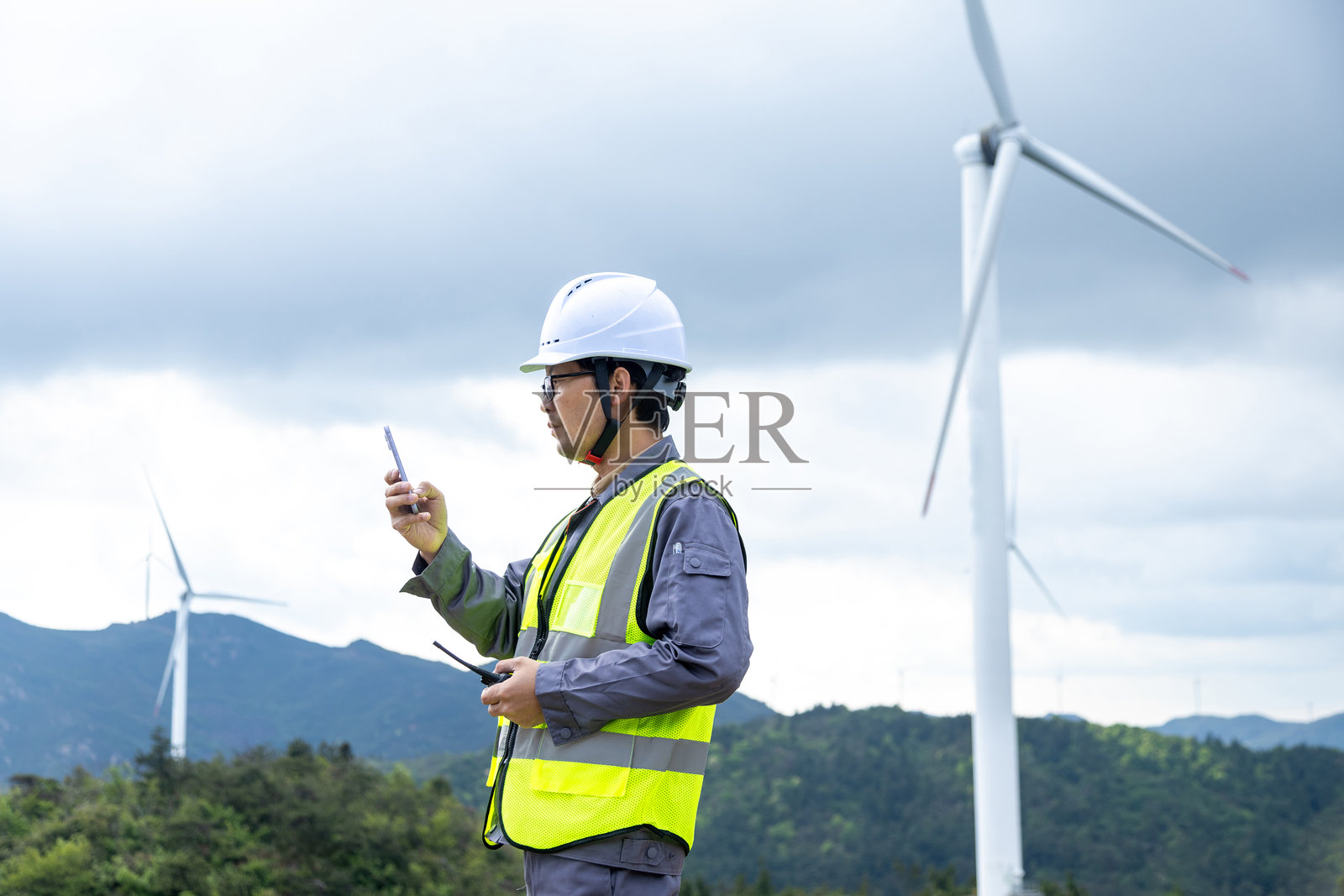 微笑的电气工程师在风电站工作照片摄影图片