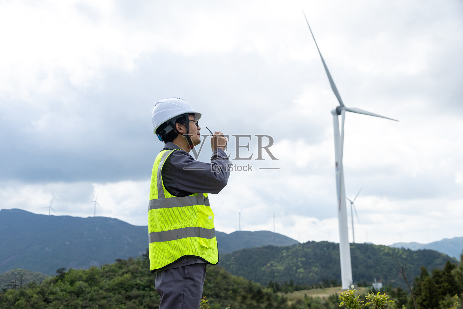 微笑的电气工程师在风电站工作照片摄影图片