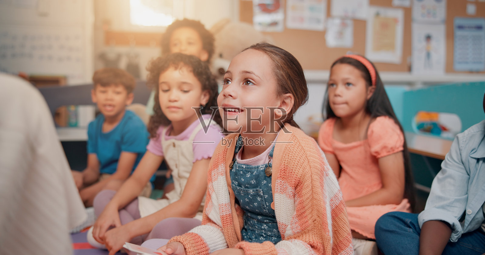 学校、课堂和孩子们在听老师讲阅读课,教育与学习。教师与学生们坐在地上进行故事讲述、语言发展和知识传授。照片摄影图片