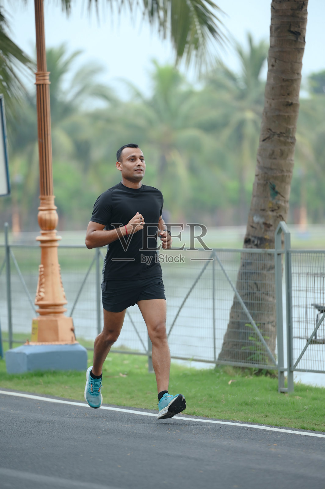 充满活力的男性跑者在热带户外路线全力奔跑照片摄影图片