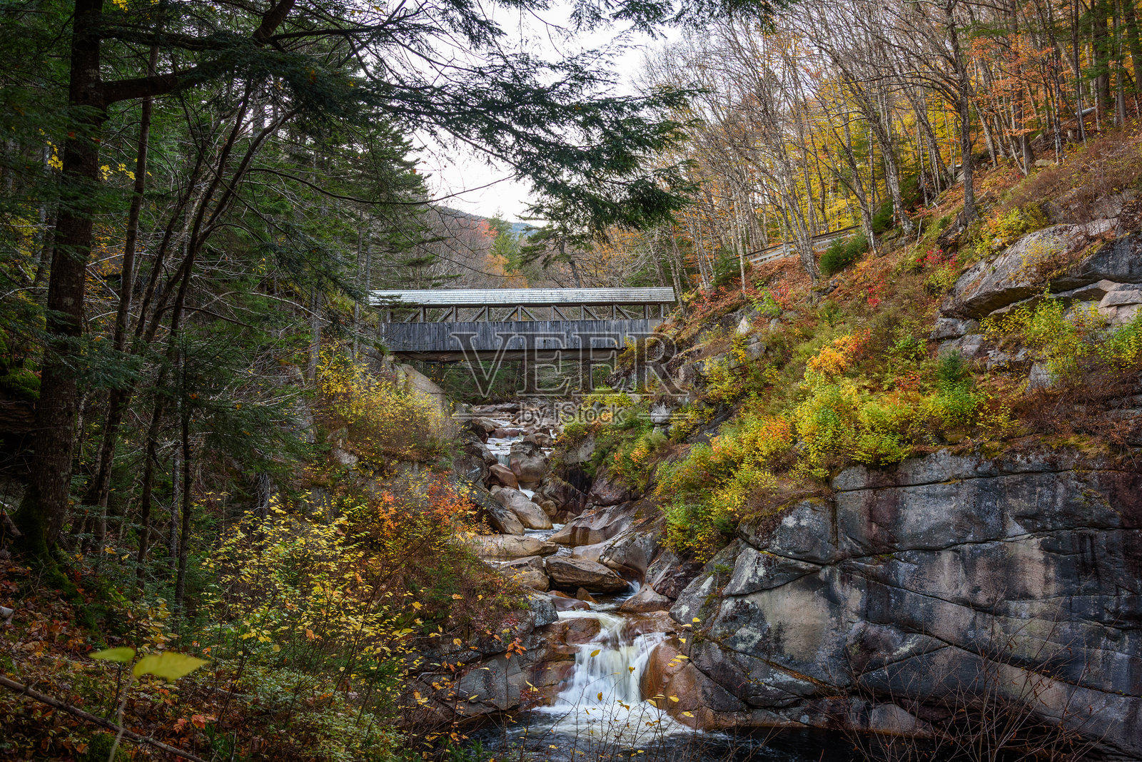 秋天日落时分,横跨峡谷的古老木制有顶桥照片摄影图片