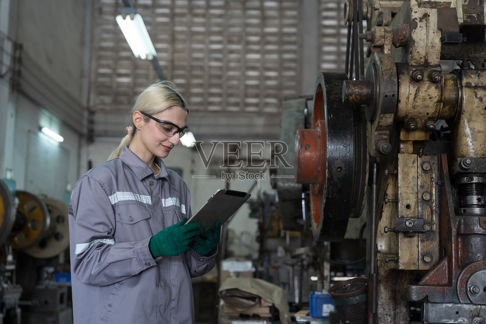 女工程师,工厂和车床机。女工程师在工业工厂工作,检查数控机床。女工厂员工维护机器。女工程师检查车床机的部件。照片摄影图片
