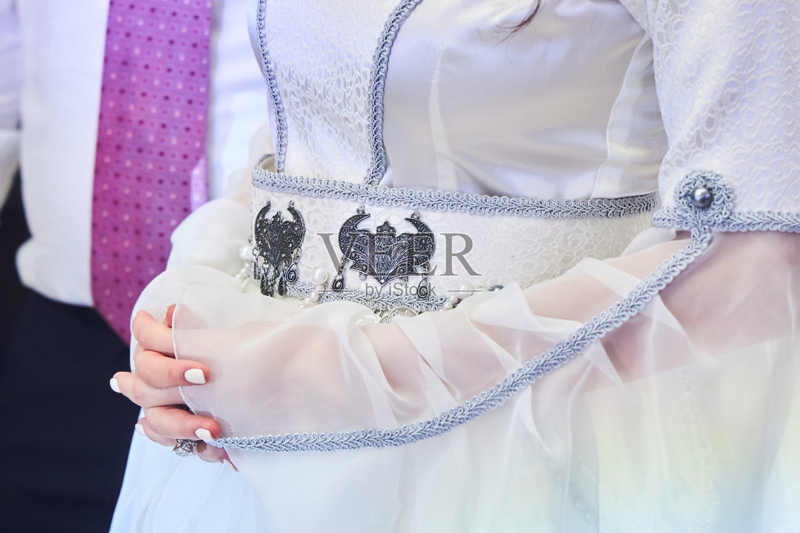 新娘的手与外高加索民族传统服饰上的腰带背景相映衬照片摄影图片