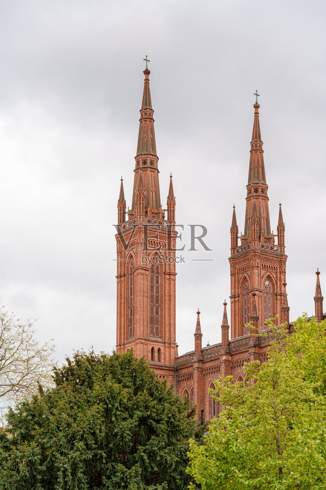 德国威斯巴登的市场教堂,一座大型红色建筑,拥有两座高耸的尖塔和一个钟楼。照片摄影图片