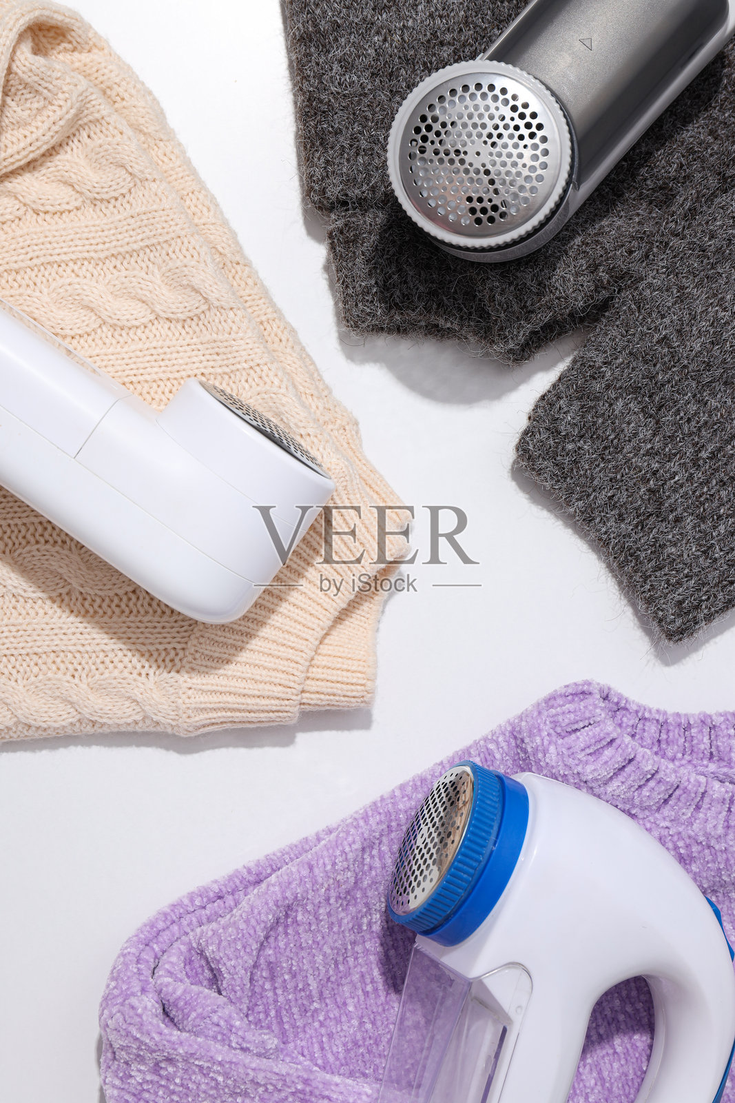 多种类型的织物剃毛器,背景为浅色。照片摄影图片