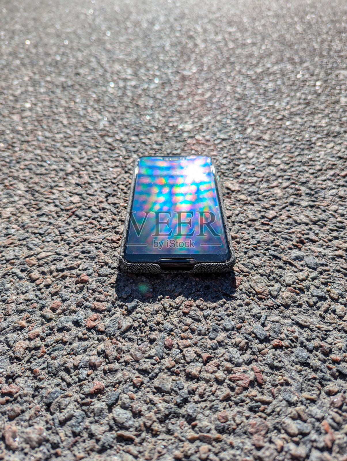 智能手机躺在沥青上照片摄影图片