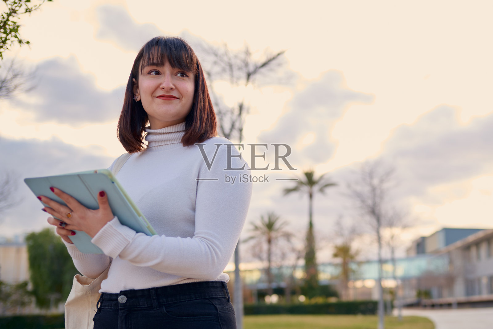 年轻女性在大学校园户外使用平板电脑照片摄影图片