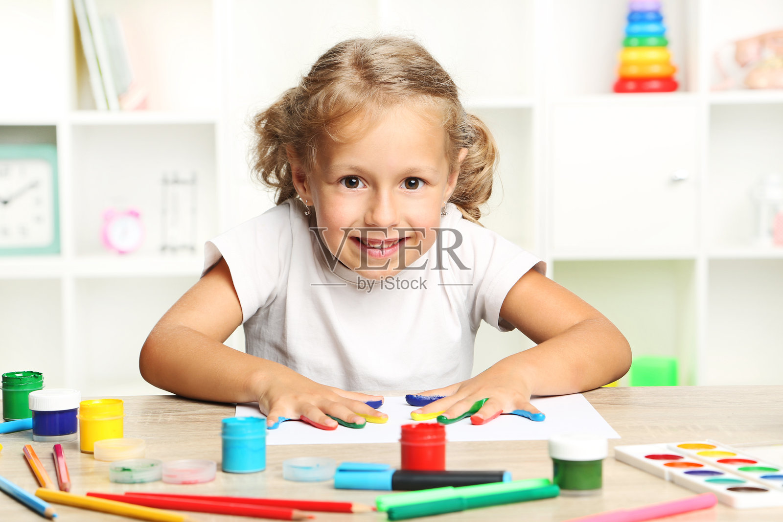 漂亮的小女孩,手上涂满了五彩缤纷的颜料照片摄影图片