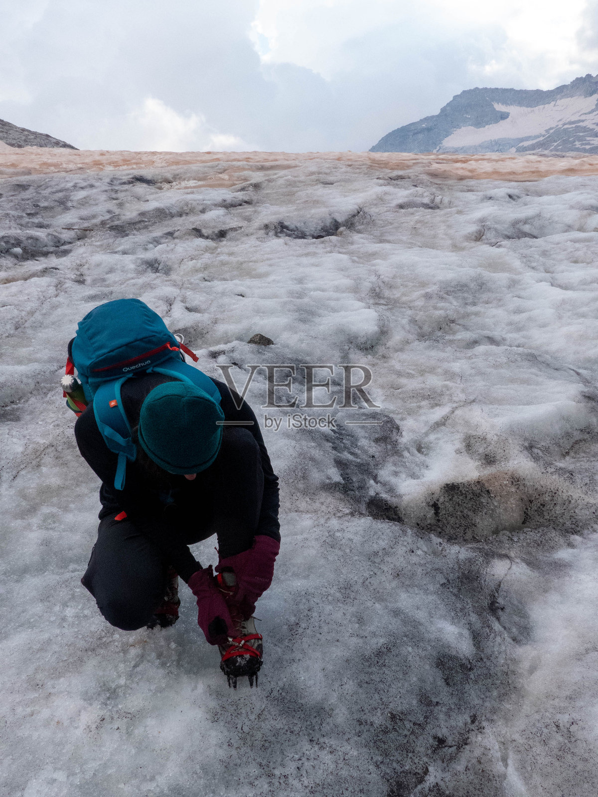 登山者在穿越冰川前穿上冰爪照片摄影图片